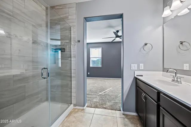 a bathroom with a granite countertop sink a mirror and shower