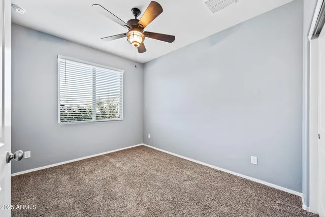 an empty room with a window and a fan
