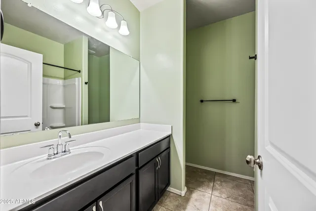 a bathroom with a double vanity sink a mirror and shower
