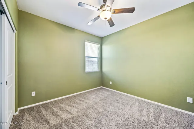 an empty room with a window and a ceiling fan