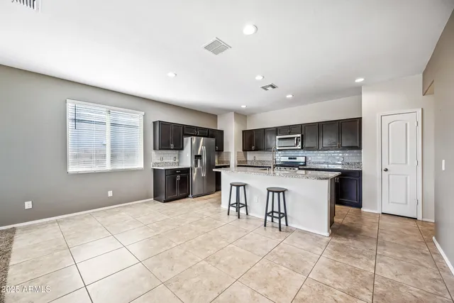 a kitchen with a sink a counter top space stainless steel appliances and cabinets