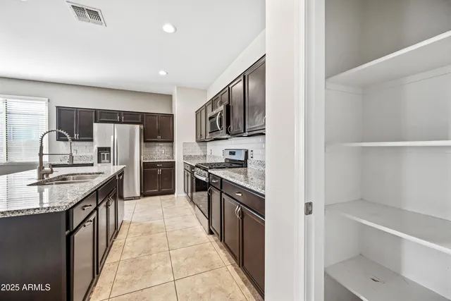 a large kitchen with stainless steel appliances granite countertop a sink and stove top oven