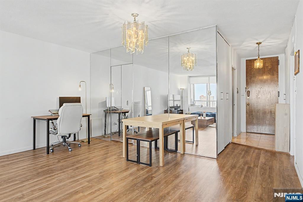 5 Horizon Road, Unit 2506 Fort Lee, NJ 07024 - Photo 5 of 20 a dining hall with a dining table chairs with wooden floor and chandelier