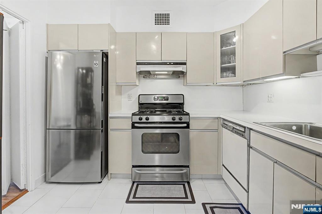 5 Horizon Road, Unit 2506 Fort Lee, NJ 07024 - Photo 6 of 20 a kitchen with refrigerator a stove and cabinets