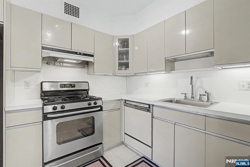 5 Horizon Road, Unit 2506 Fort Lee, NJ 07024 - Photo 7 of 20 a kitchen with cabinets stainless steel appliances a stove and a sink