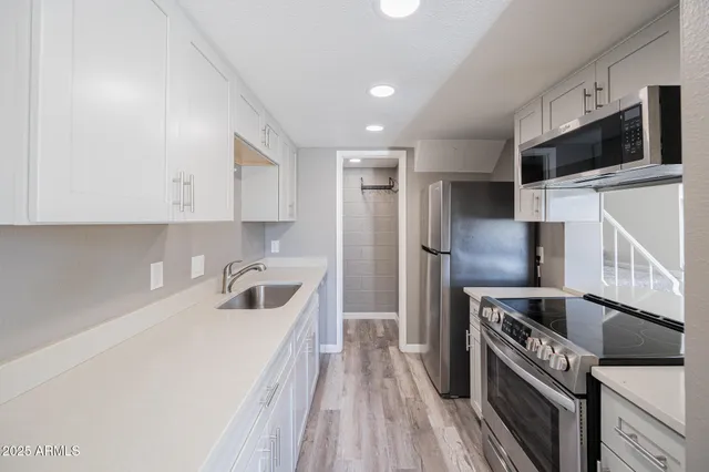 a kitchen with a refrigerator a stove and a sink