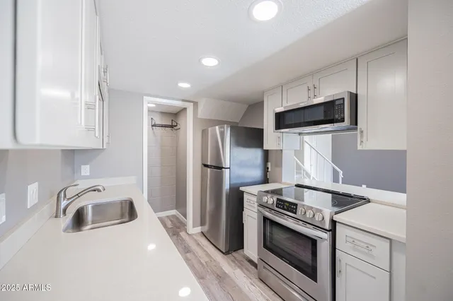 a kitchen with a sink a stove and refrigerator