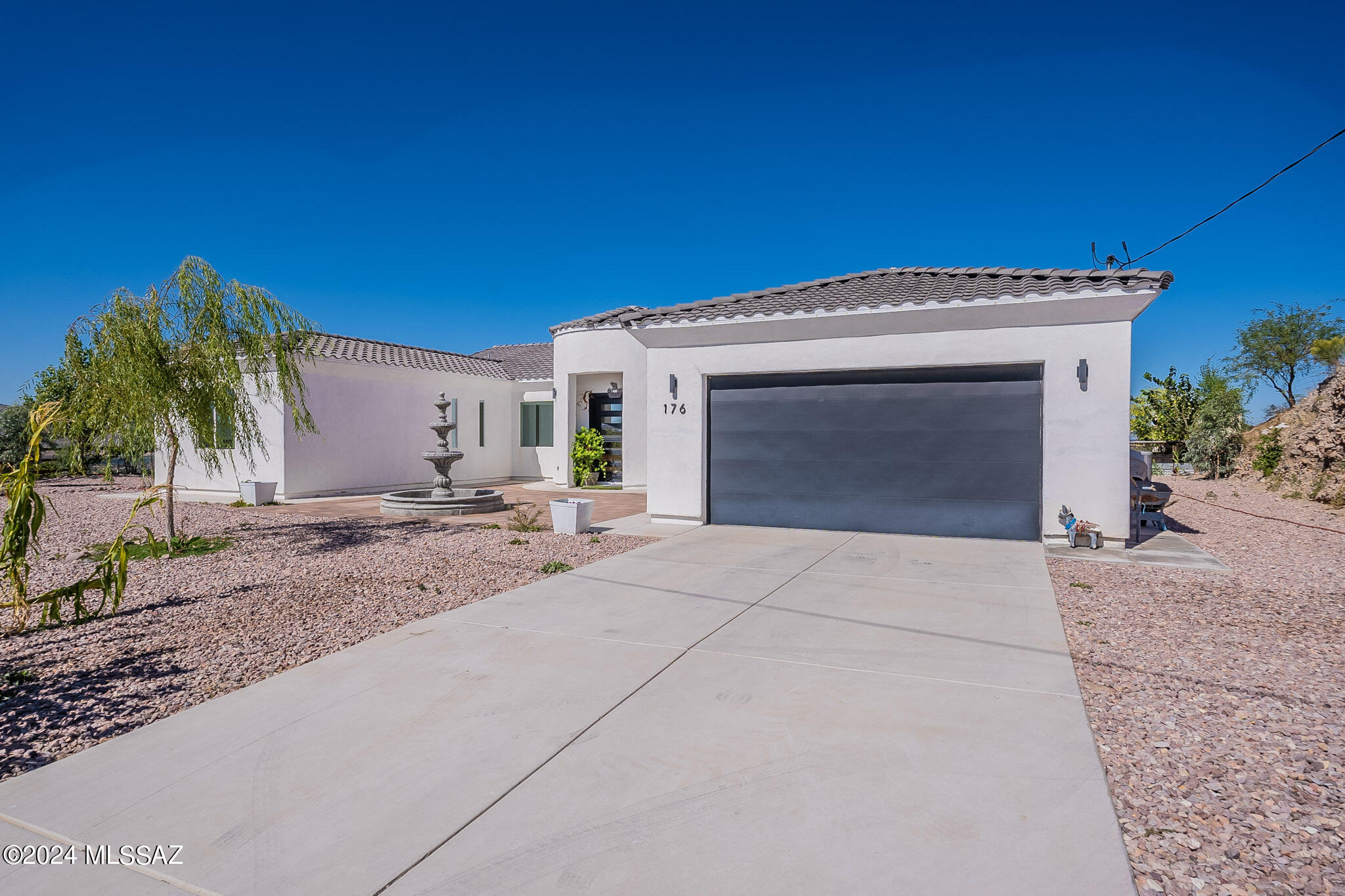 176 Avenida Ostion Rio Rico, AZ 85648 - Photo 7 of 48 a front view of a house with a yard and garage