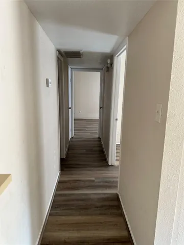 a view of a hallway with wooden floor and entryway