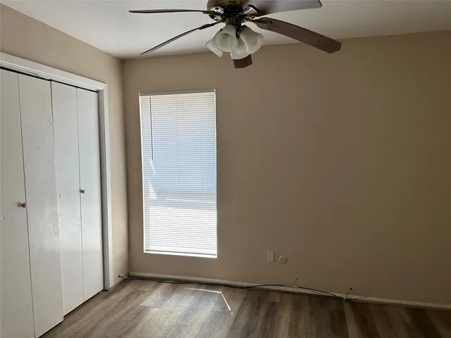 an empty room with a window and wooden floor