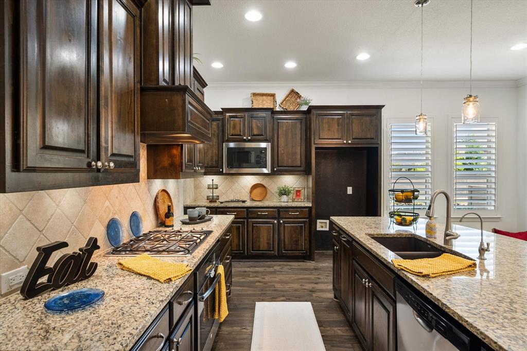 1201 9th Street Argyle, TX 76226 - Photo 11 of 40 a kitchen with stainless steel appliances granite countertop a sink stove and refrigerator