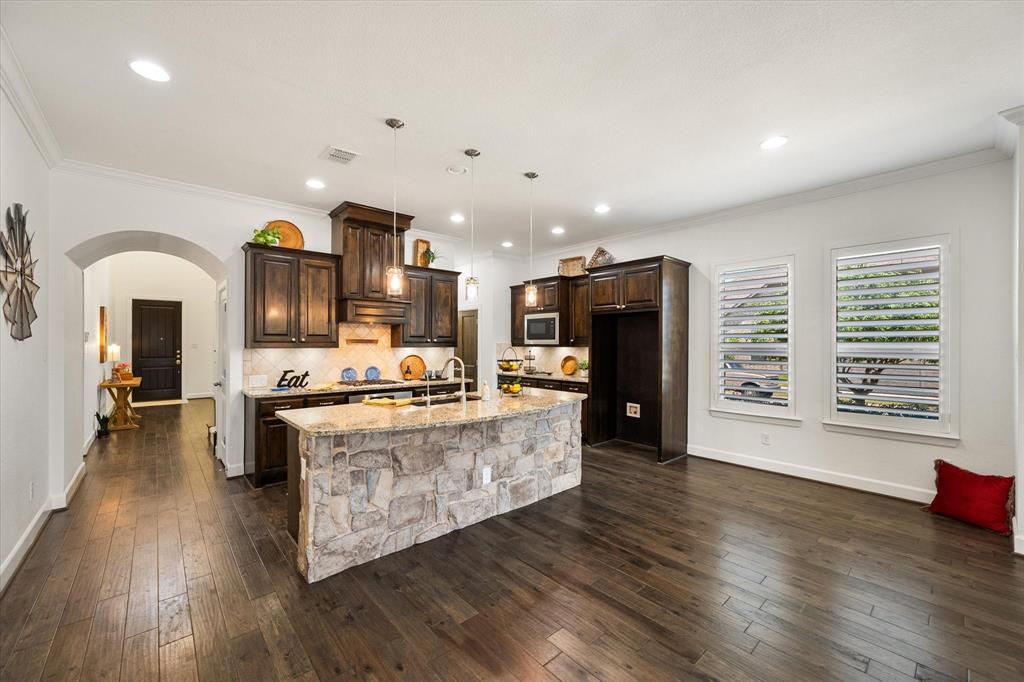 1201 9th Street Argyle, TX 76226 - Photo 12 of 40 a large kitchen with stainless steel appliances granite countertop a stove and a wooden floors
