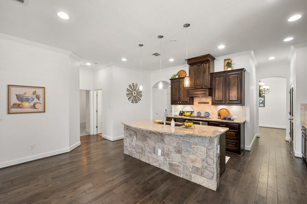 1201 9th Street Argyle, TX 76226 - Photo 13 of 40 a large kitchen with stainless steel appliances granite countertop a lot of counter space and wooden floor