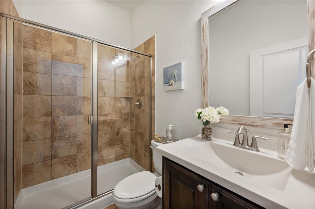 1201 9th Street Argyle, TX 76226 - Photo 23 of 40 a bathroom with a sink a toilet and shower