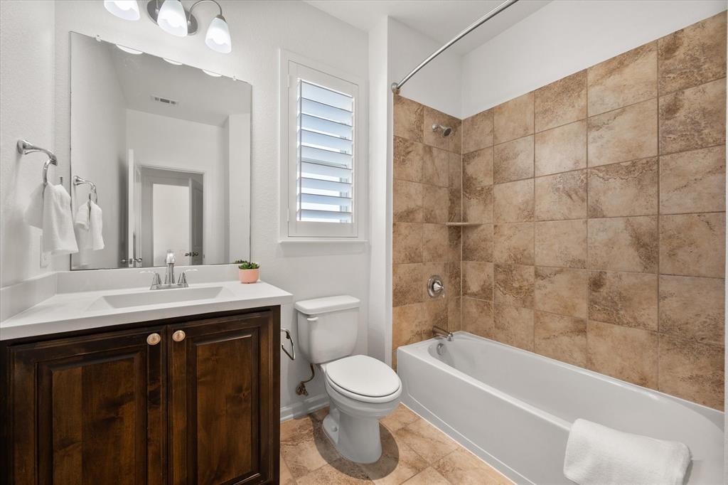 1201 9th Street Argyle, TX 76226 - Photo 28 of 40 a bathroom with a sink a toilet a mirror a bathtub and shower