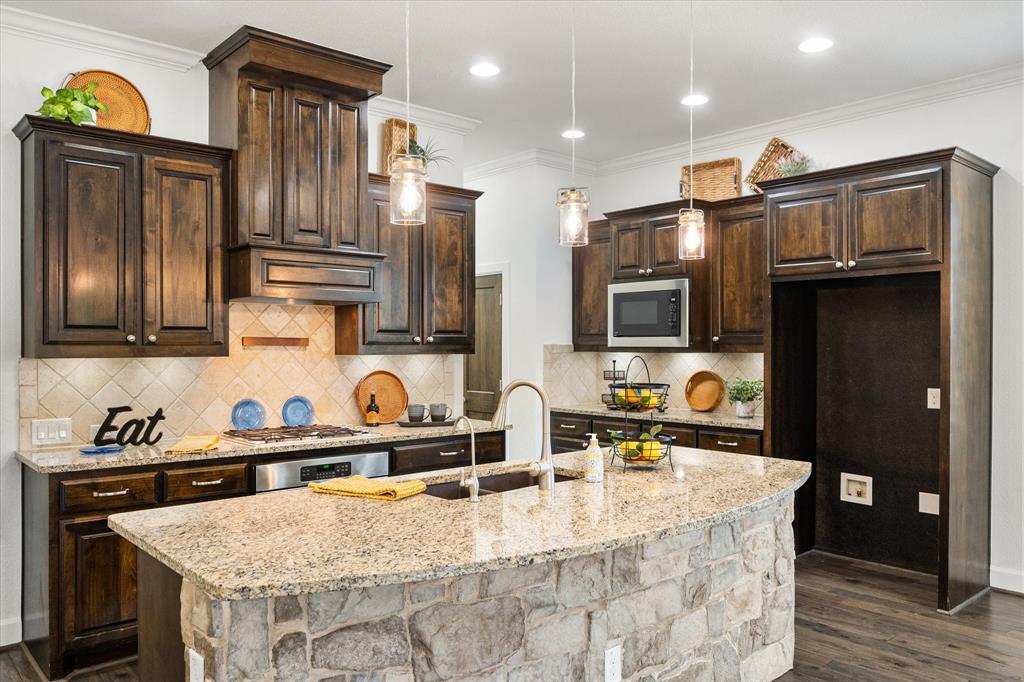 1201 9th Street Argyle, TX 76226 - Photo 9 of 40 a kitchen with stainless steel appliances granite countertop a sink a stove and a refrigerator