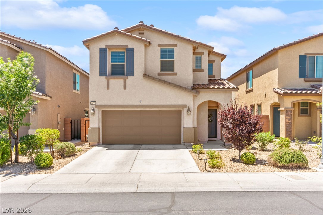 6435 Point Isabel Way Las Vegas, NV 89122 - Photo 4 of 57 A welcoming facade with a garage, arched entryway, and neatly landscaped front yard.
