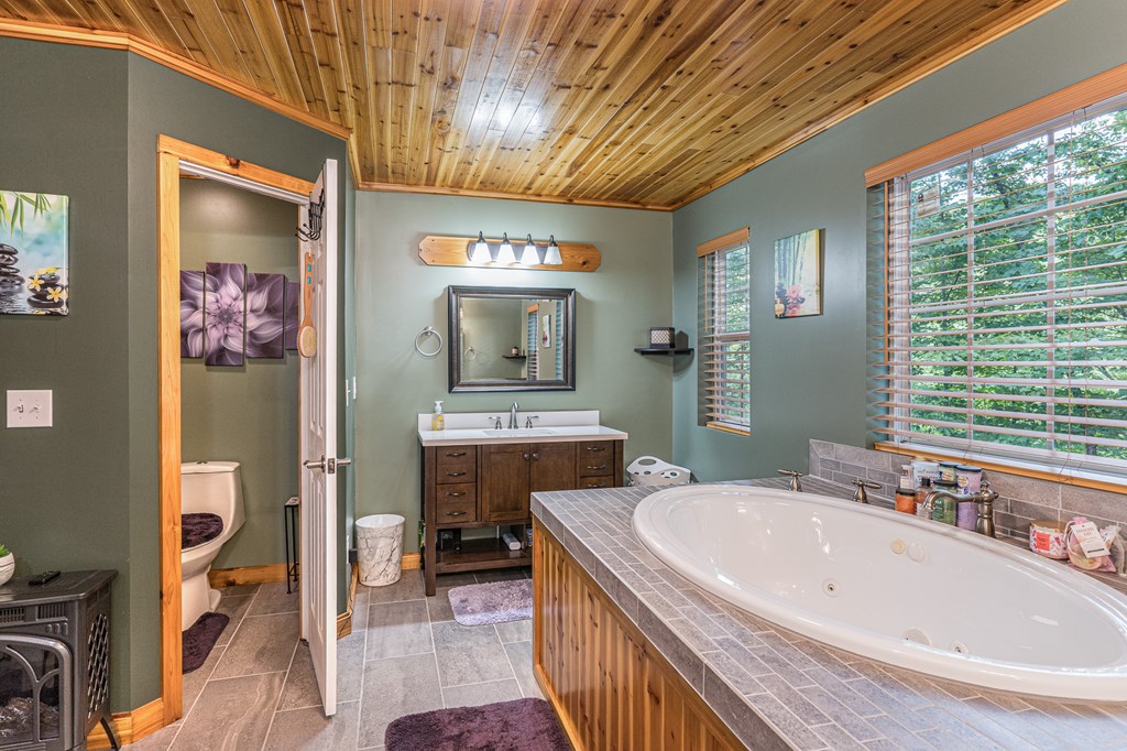 140 Kathryn Circle Murphy, NC 28906 - Photo 29 of 55 a bathroom with a granite countertop sink a mirror a bathtub and shower