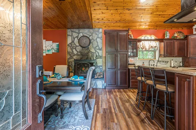 a dining room with furniture a fireplace and wooden floor