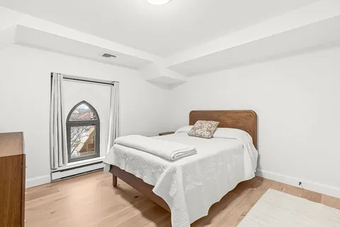 a bedroom with a bed and a large window
