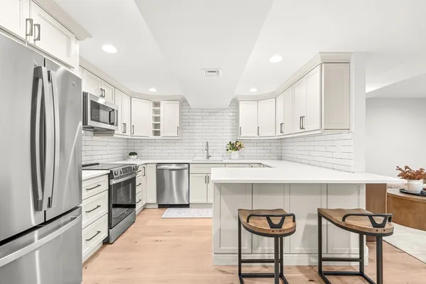 a kitchen with stainless steel appliances granite countertop a sink and a refrigerator