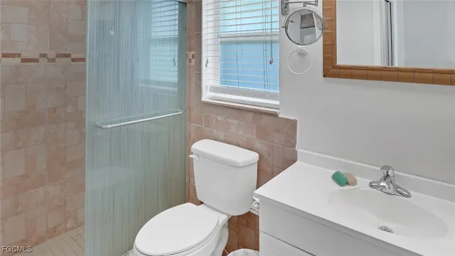 a white toilet sitting next to a bathroom sink