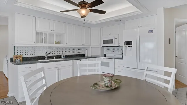 a kitchen with white cabinets and appliances