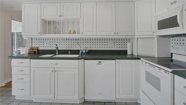 a kitchen with granite countertop a sink cabinets and stainless steel appliances
