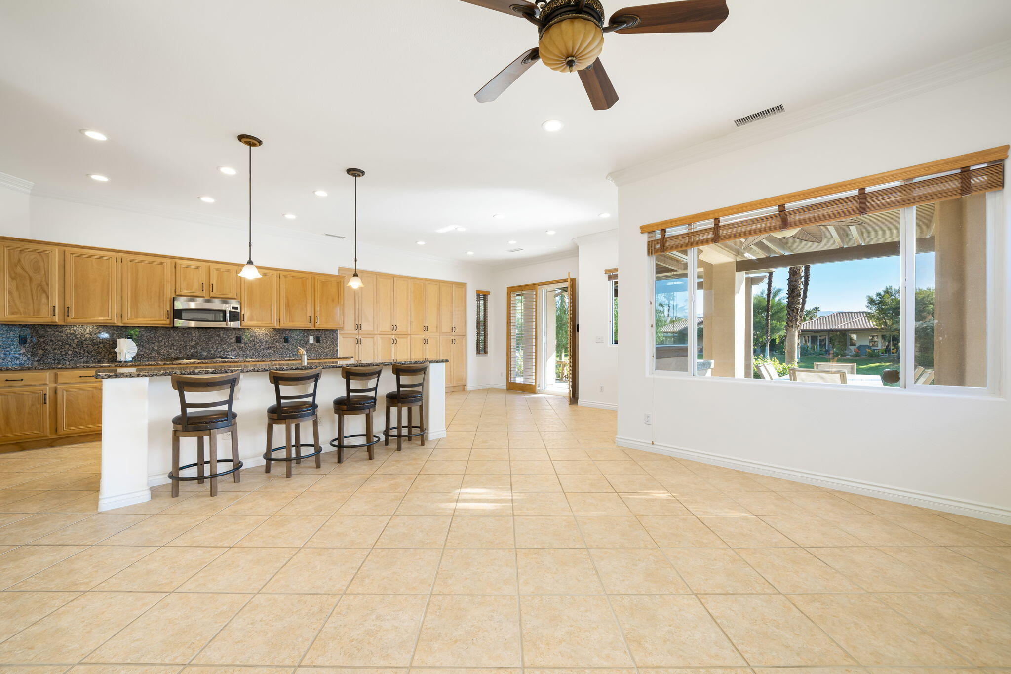27 Racquet Club Drive South Rancho Mirage, CA 92270 - Photo 14 of 44 a view of a kitchen with kitchen island stainless steel appliances wooden floor dining table and chair