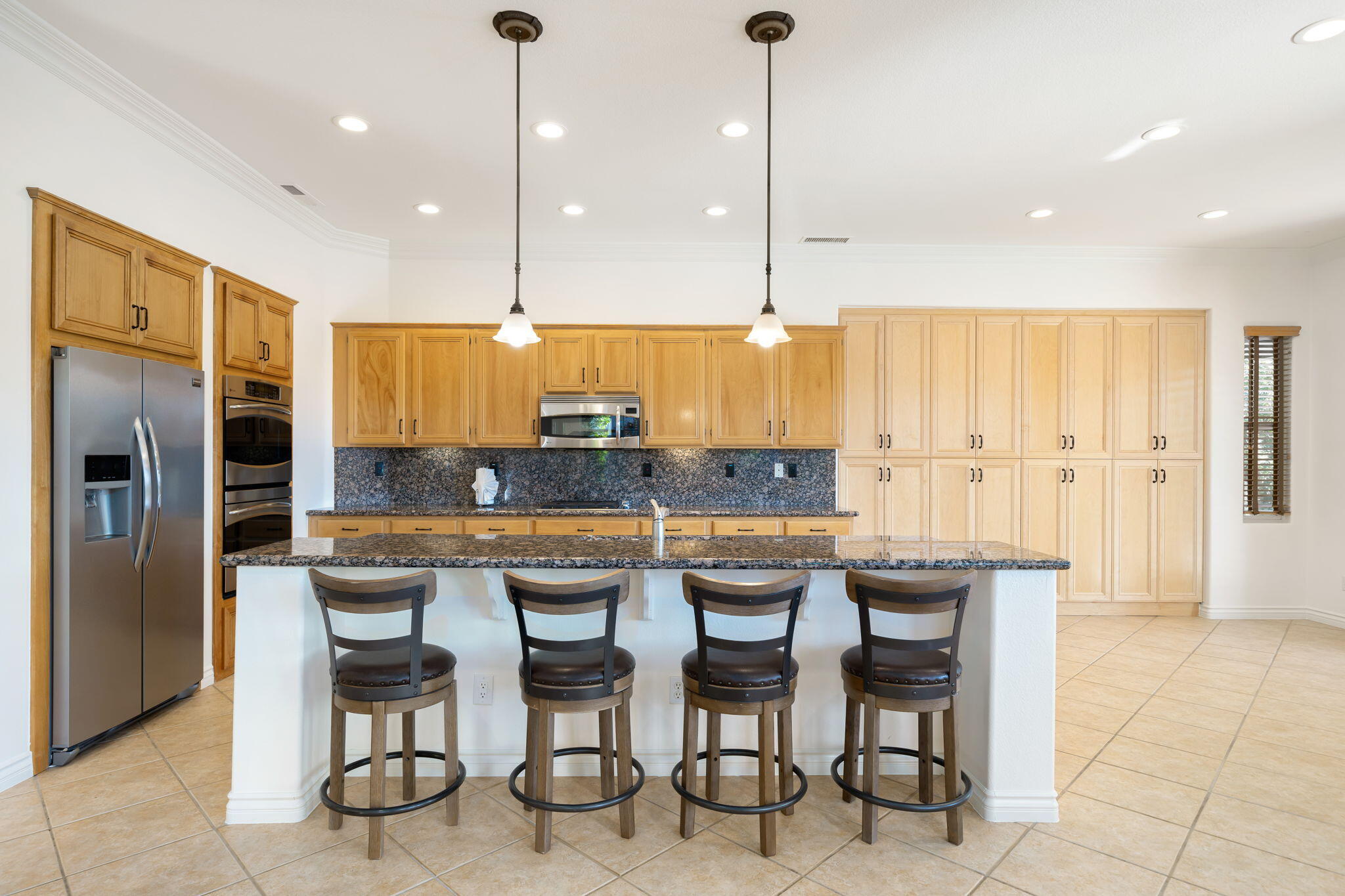 27 Racquet Club Drive South Rancho Mirage, CA 92270 - Photo 19 of 44 a kitchen with stainless steel appliances granite countertop table chairs sink and stove top oven
