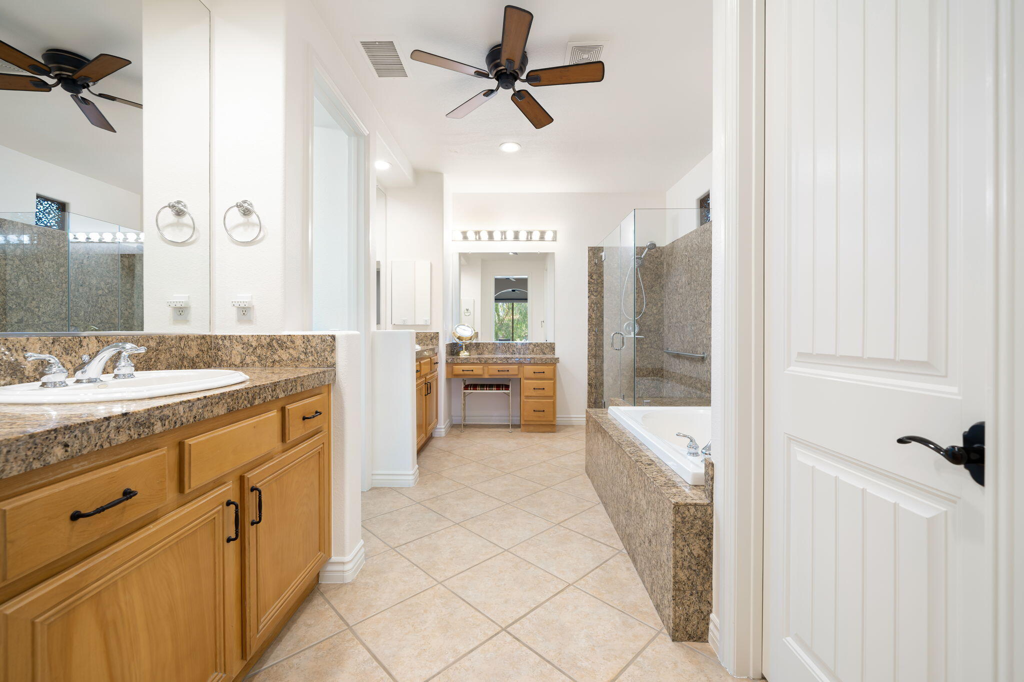 27 Racquet Club Drive South Rancho Mirage, CA 92270 - Photo 35 of 44 a spacious bathroom with a granite countertop sink a mirror a shower and a bathtub