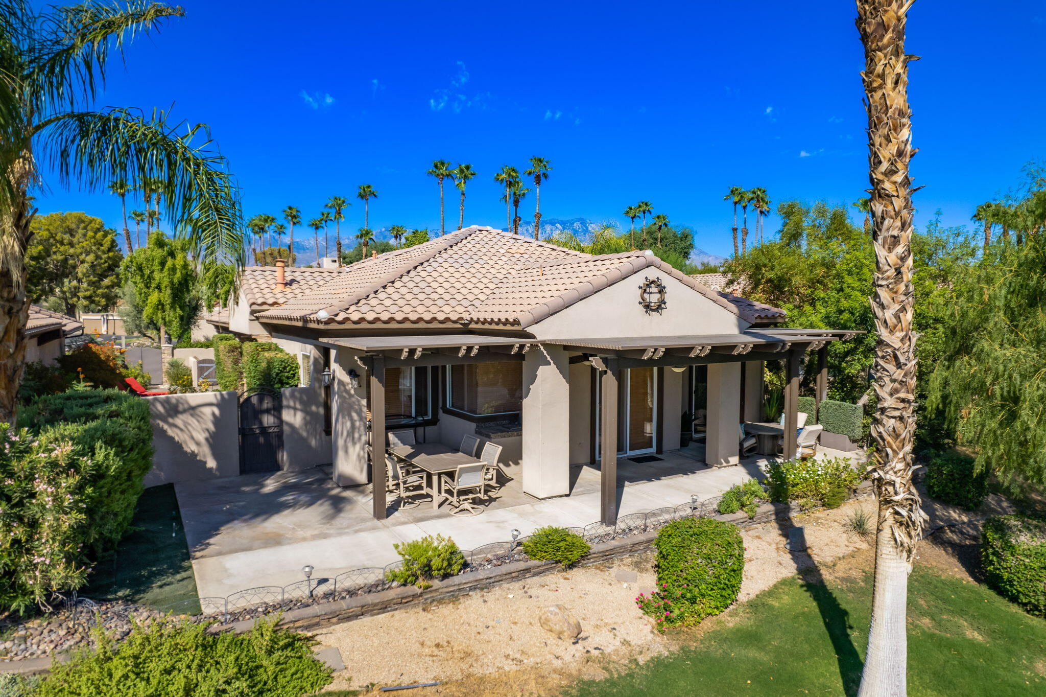 27 Racquet Club Drive South Rancho Mirage, CA 92270 - Photo 5 of 44 a view of a patio with table and chairs under an umbrella with potted plants
