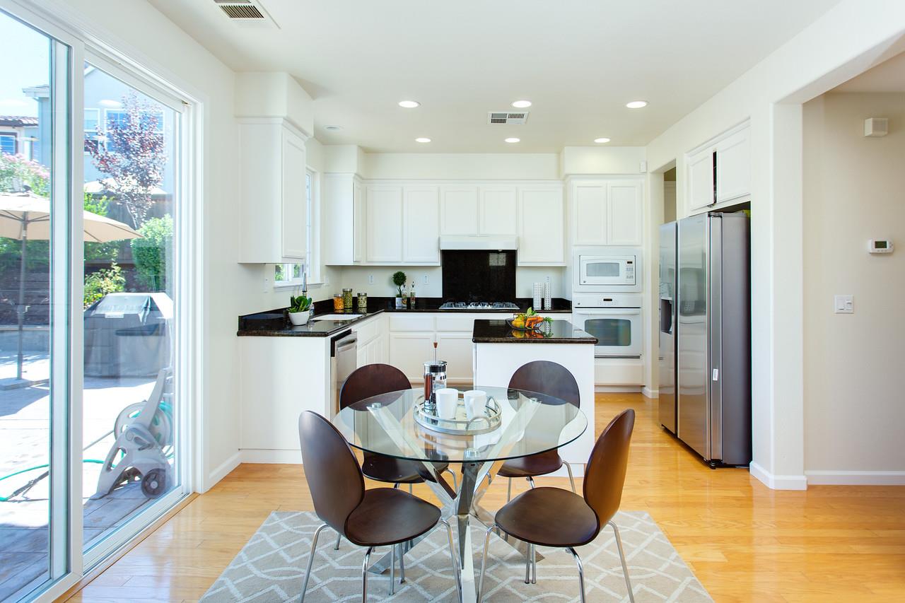 1615 Farringdon Way San Ramon, CA 94582 - Photo 5 of 18 a kitchen with stainless steel appliances kitchen island granite countertop a refrigerator a stove a microwave oven with a dining table and chairs