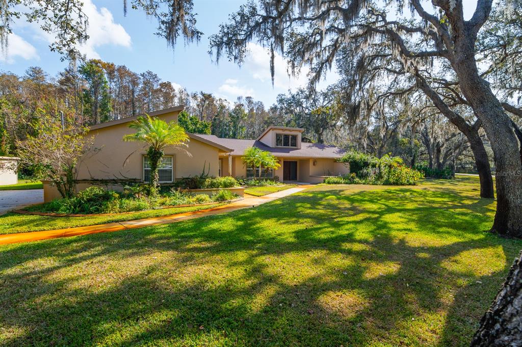 a view of an house with backyard space and balcony