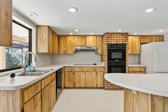 a kitchen with stainless steel appliances granite countertop a sink a stove and a microwave