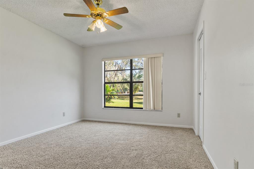10206 Lakeview Drive New Port Richey, FL 34654 - Photo 29 of 53 an empty room with windows and fan