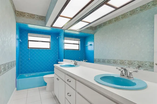 a bathroom with a granite countertop sink a toilet and a mirror