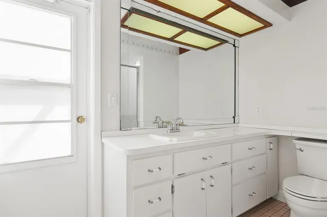 a bathroom with a sink and a mirror next to a window