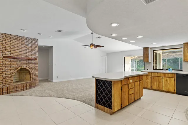 a view of kitchen with kitchen island stainless steel appliances a sink counter space and a window
