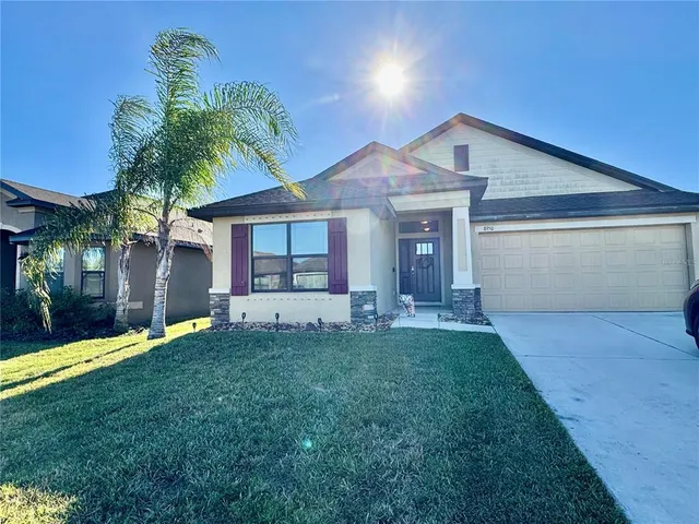 a view of a house with a yard and palm tree