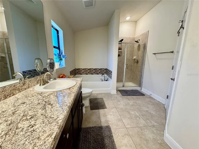 a spacious bathroom with a toilet sink and mirror