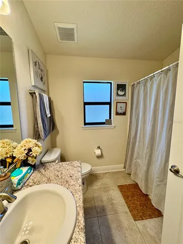 a bedroom with a bed a wall painting on the wall and a window