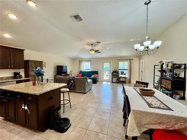 a living room with furniture kitchen view and a chandelier