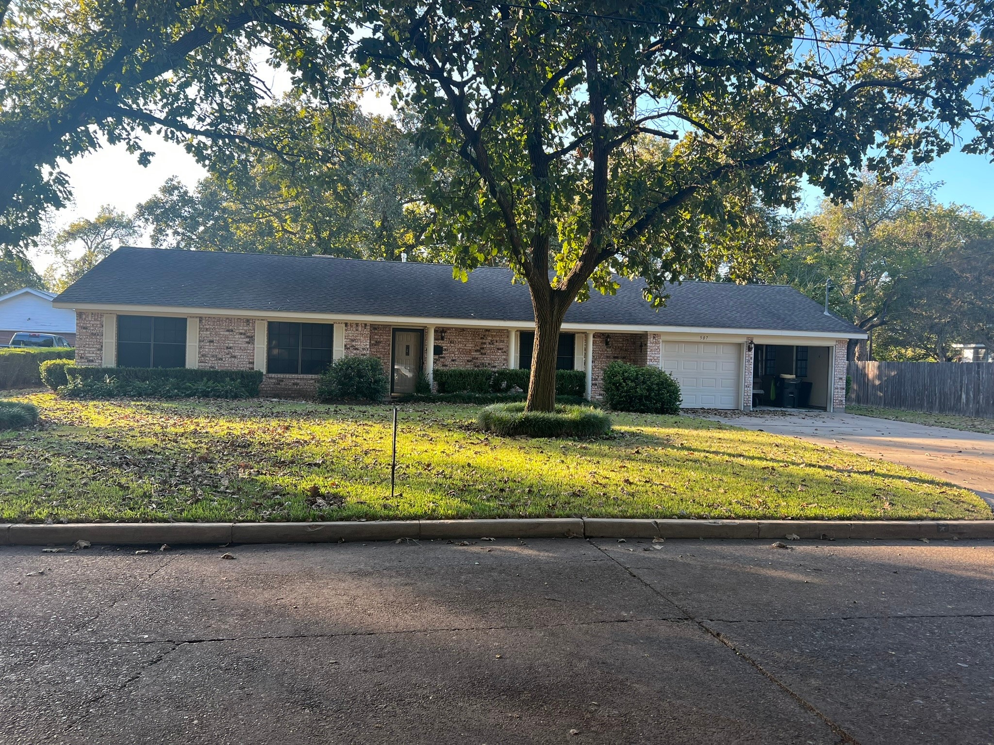 a view of house with a yard and large trees