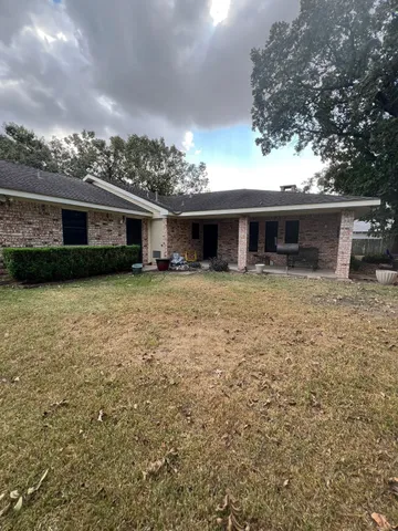 a front view of house with yard and trees in the background