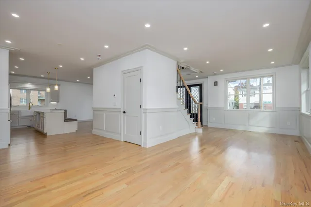 a kitchen with a sink stainless steel appliances and wooden floor