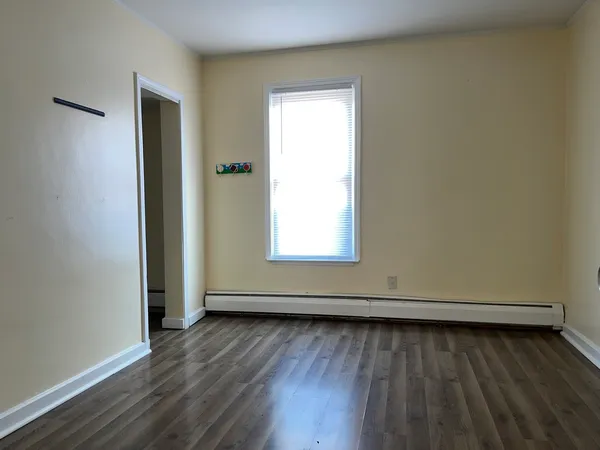 an empty room with wooden floor and a window