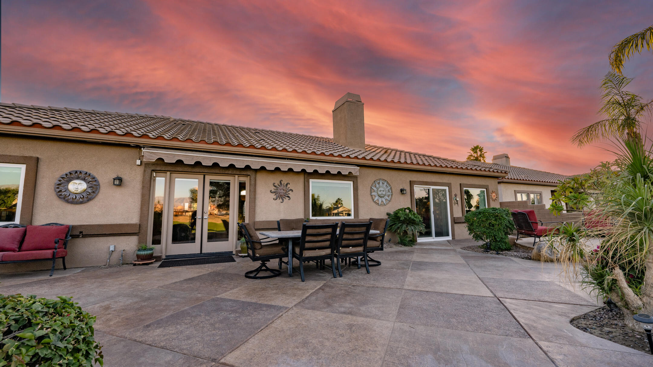 80290 Pebble Beach Drive Indio, CA 92201 - Photo 5 of 44 a view of a patio with table and chairs with plants and wooden fence