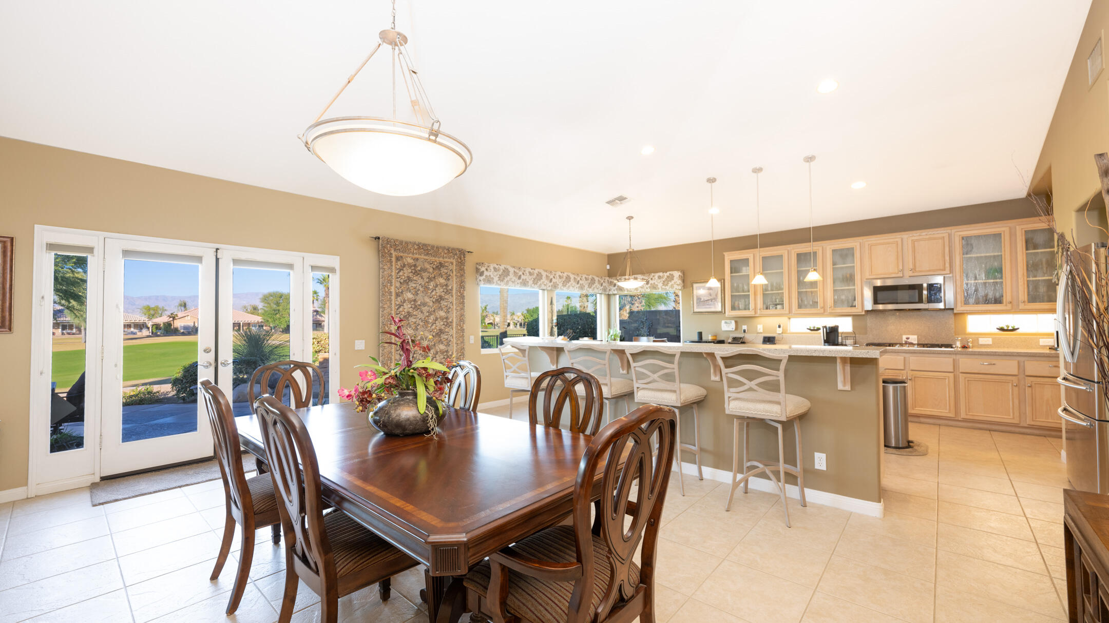 80290 Pebble Beach Drive Indio, CA 92201 - Photo 10 of 44 a dining room with stainless steel appliances granite countertop a dining table and chairs