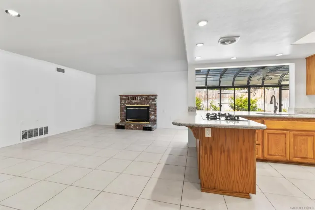 a view of an empty room with a fireplace and a window